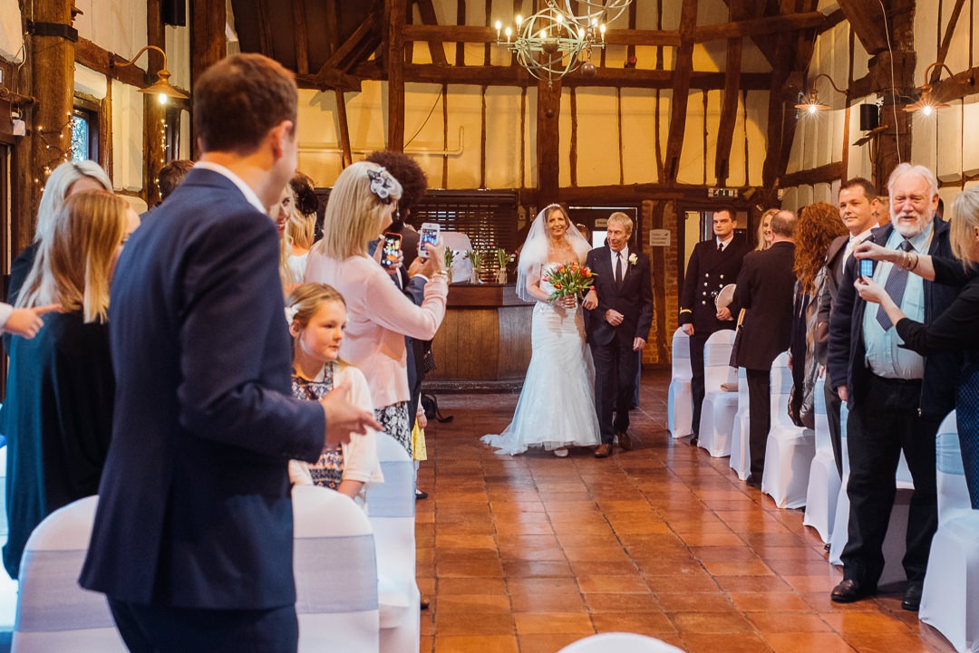 Bride walks down the aisle at the Tithe Barn, Bedford.