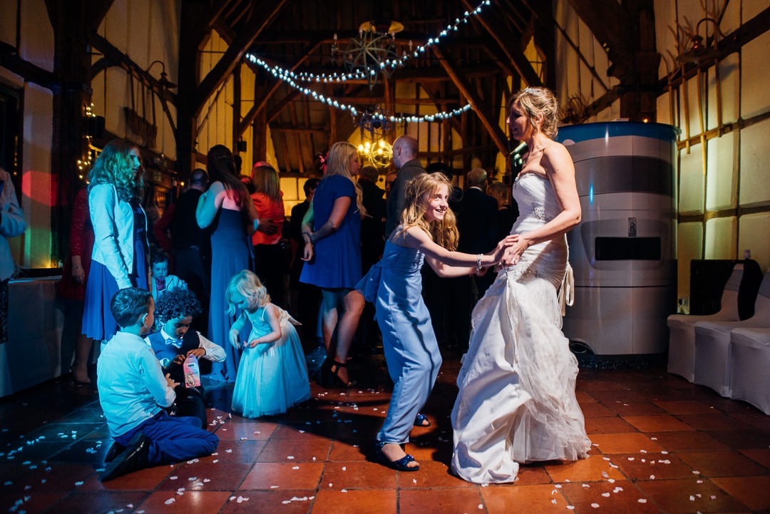 The bride dances with a child during the recpetion at at the Tithe Barn, Bedford.