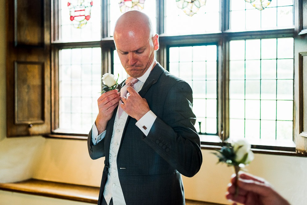 Groom placing Button hole at Sulgrave Manor