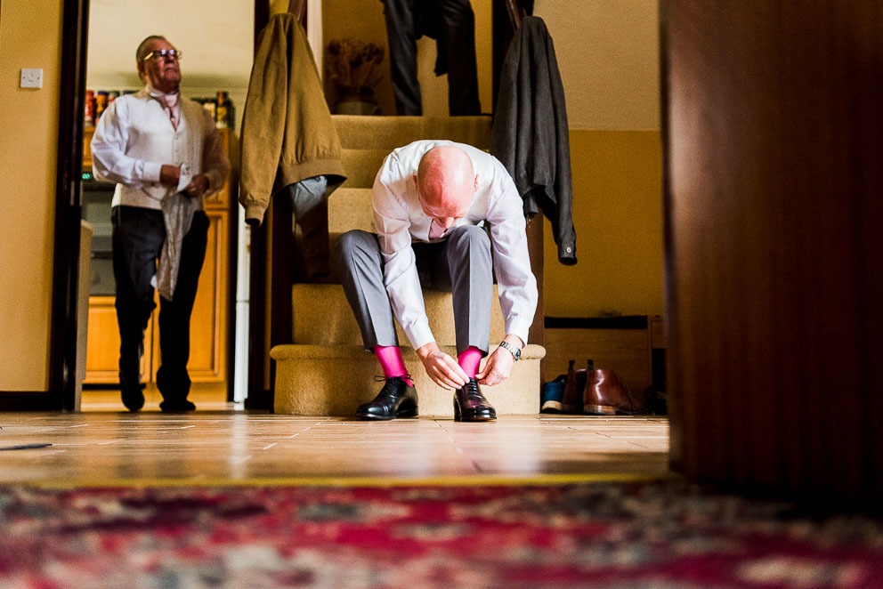Groom tying shoes at home