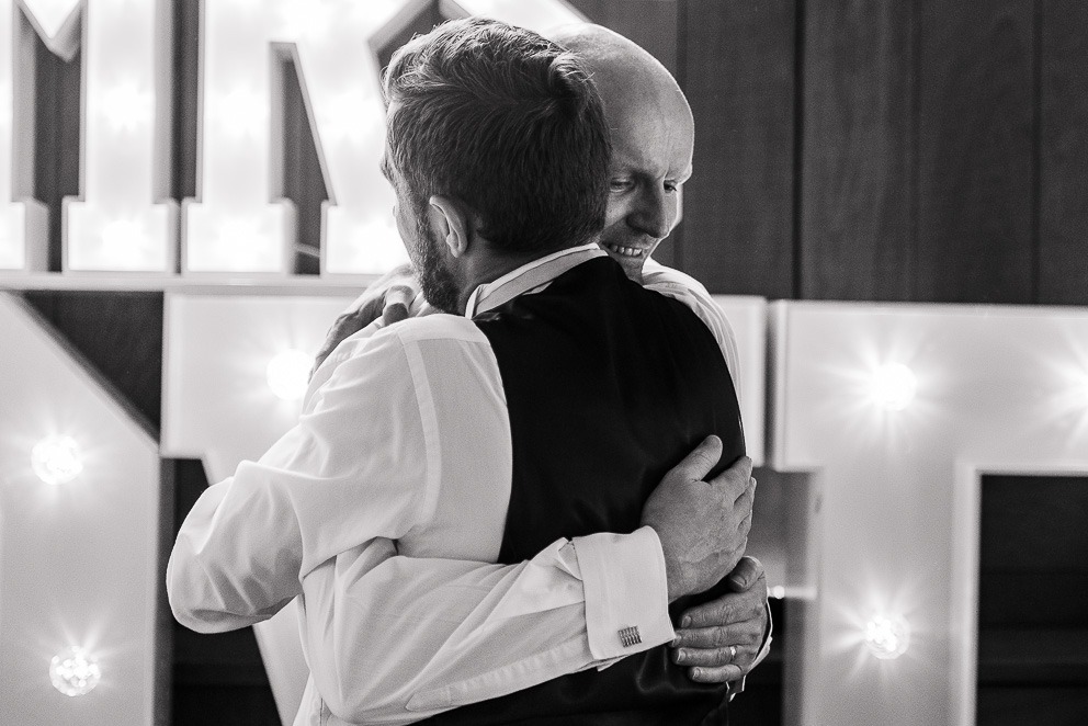 Groom hugging guest at Sulgrave Manor